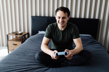 Young man laughing and playing video games on weekend