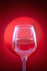 Glass of wine on red background