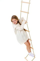 Little girl plays on a rope ladder.