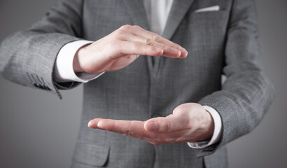 Obraz premium Businessman shows a protective gesture with his hands.