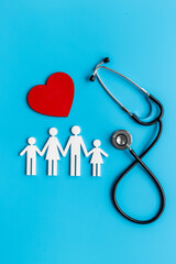 Flat lay with heart, stethoscope and family figure. Medical care concept