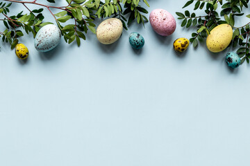 Frame of Easter eggs with spring branches and green leaves. Veiw from above