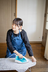 家事、アイロンがけをする女性 © haru