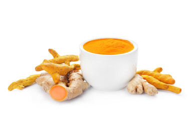 Bowl with turmeric powder and roots on white background