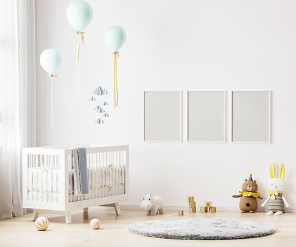 Blank poster frames mock up on white wall in nursery room interior background with baby bedding, soft toys, balloons, 3d rendering