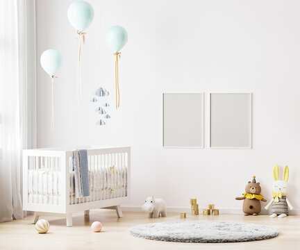 Blank poster frames mock up on white wall in nursery room interior background with baby bedding, soft toys, balloons, 3d rendering
