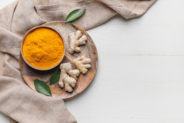 Composition with turmeric powder on white wooden background