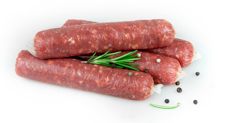 Raw meat sausages. Rosemary, pepper. White background.