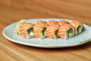 Closeup shot of Philadelphia sushi rolls with salmon, avocado, cream cheese laid out on a white plate