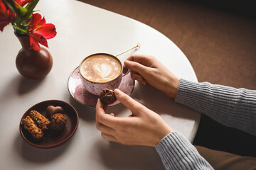 Woman with cup of latte at table in cafe