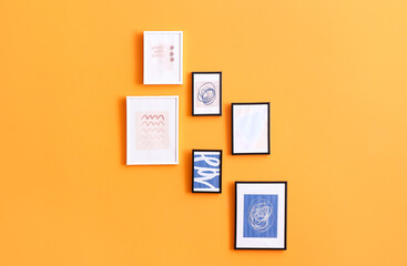 Stylish frames with pictures hanging on color wall