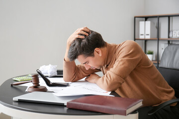 Stressed man at table in office. Bankruptcy concept