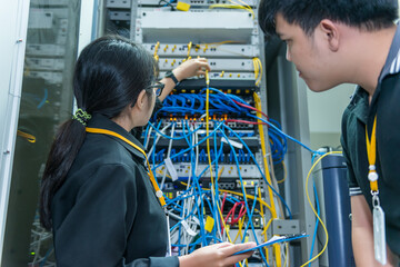 Two asian engineers working in the server room,Check the connection problems of computer networks,Thailand people