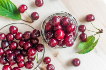 Fresh cherries in jar, sweet eating, on a wooden table. Top view. Spase for text.