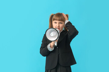 Fototapeta premium Stressed little schoolgirl with megaphone on color background