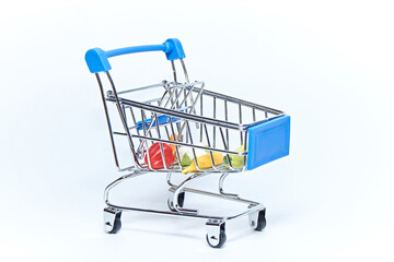 Blue mini grocery cart from supermarket with groceries on white background. Consumer concept.