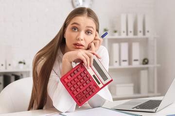 Stressed female accountant with calculator working in office