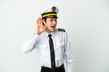 Airplane Russian pilot isolated on white background listening to something by putting hand on the ear