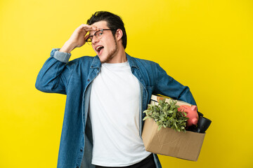 Russian Man making a move while picking up a box full of things isolated on yellow background doing...
