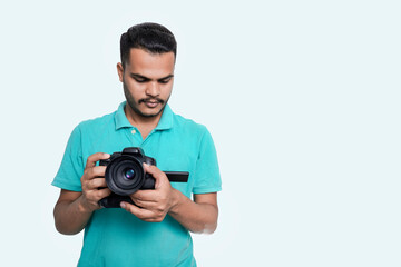 man with a professional DSLR camera, showing thumbs up, checking  photos, showing the camera, operating the camera, with a blank white plate