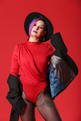 Portrait of extravagant stylish woman on color background