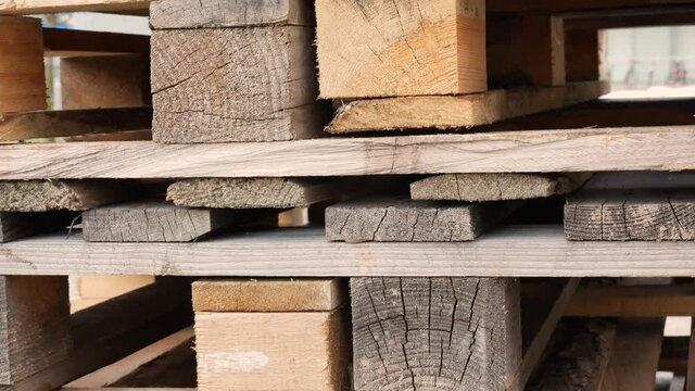 Wooden transport pallets stacked, slow tilt up, pallet pile, simple object background texture, nobody, detail. Transport, shipping, goods warehouse concept, industrial pallets stacked extreme closeup