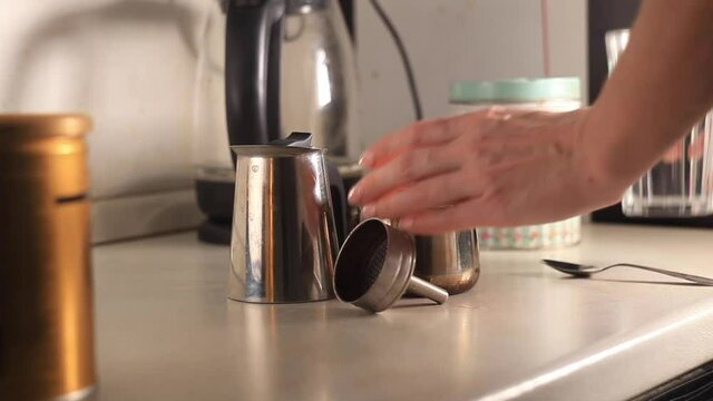 The process of making coffee. Women's hands are taken in close-up. Woman pours water and pours coffee into geyser coffee maker. High quality footage