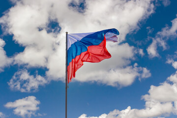 Waving flag of Russia on a pole against sky background
