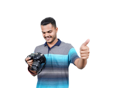 man with a professional DSLR camera, showing thumbs up, checking  photos, showing the camera, operating the camera, with a blank white plate