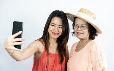 Asian young and senior women using on mobile phone and standing on white background