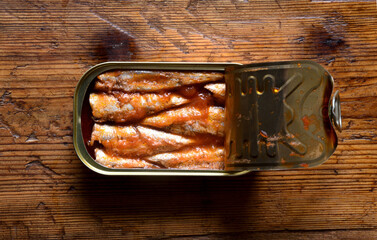 can of sardines with tomato sauce on wooden background