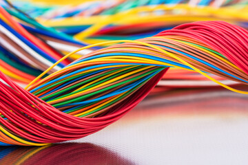 Colorful electrical and telecommunication cable wire on shiny metal surface with reflection