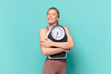 young pretty sport woman happy expression and holding a weight scale