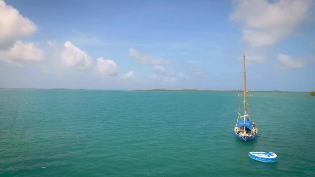 Aerial view of a sail boat in a beautiful blue Caribbean Sea with clear skies
