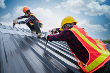 Team work Roofer worker safety wear using air or pneumatic nail gun and installing on new roof...