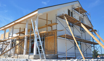 Modern house repair and renovation. Plastering, applying stucco and painting the facade walls using...