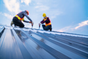 Selective focus roof, construction worker safety wear using electric drill tools install on new...