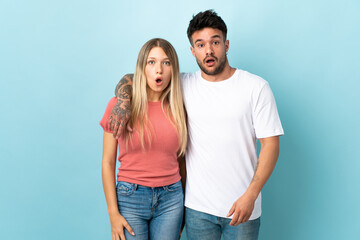 Fototapeta premium Young caucasian couple isolated on blue background with surprise facial expression