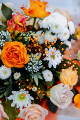 The table is decorated with orange and yellow flowers. gerbera, roses and rose mix. Gypsophila and calendula. Spring decor.