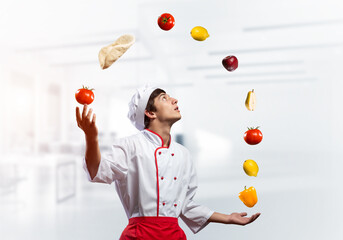 Young male chef juggles with food ingredients