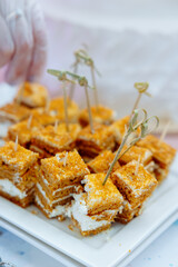 Tasting of sliced ​​pieces of cake on skewers. sweet pie snacks. puff pastry cake with cream.