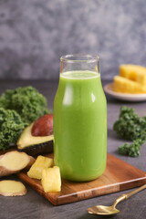 A glass of natural and healthy kale smoothie with varieties fruit and herb such as pineapple, avocado, ginger. A plant base medical concept. Fresh green juice improve a digestive, immunity support