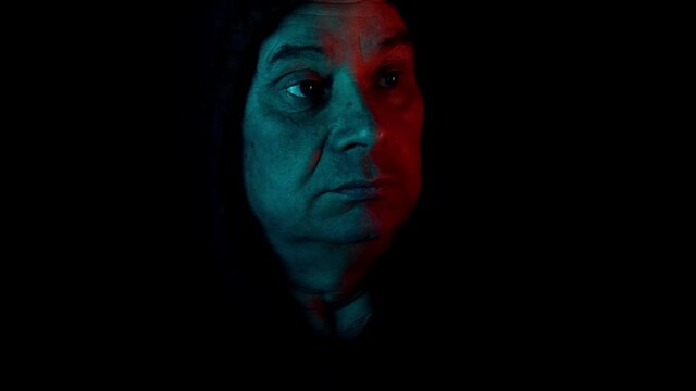middle-aged man, stalker in hood looks through black binoculars in dark, peeps, illegally tracks down personal secrets of neighbors, concept of industrial espionage, surveillance