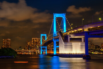 Fototapeta na wymiar Beautiful night scene of famous Rainbow Bridge glowing blue, Illumination of thanks to medical staff Tokyo, Japan, travel background