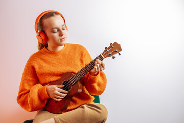 A girl plays the ukulele