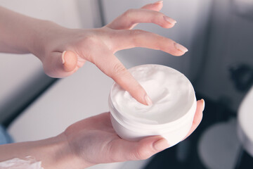 girl smears cream on her hands
