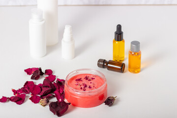 Obraz na płótnie Canvas Jar of cosmetic body scrub with rose petals. Natural cosmetic. Home cosmetics