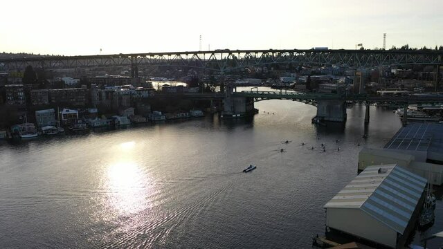 Cinematic sunset aerial drone footage of houseboats on Lake Union, the Ship Canal Bridge with highway I-5, Capitol Hill, Eastlake, Portage Bay near downtown Seattle in King County, Washington