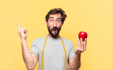 young crazy bearded man dieting celebrating successful a victory and holding an apple