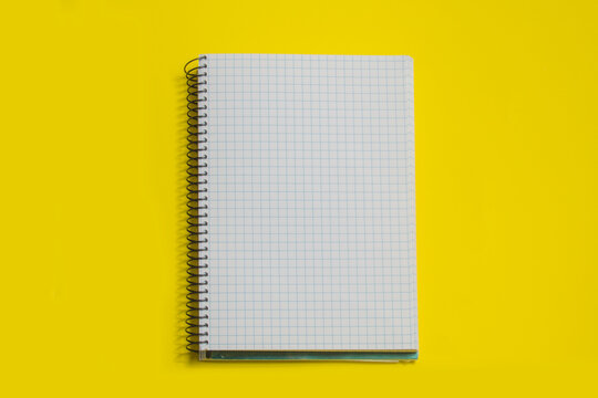 squared sheets spiral notebook, isolated on yellow background